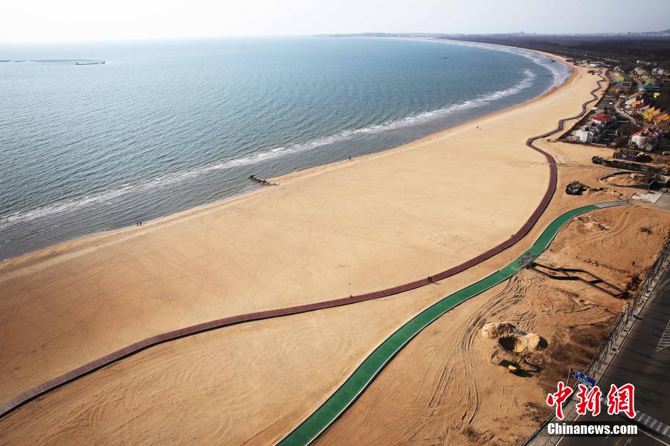 3月13日，秦皇島萬(wàn)米臨海沙灘木棧道。據(jù)了解，該木棧道全長(zhǎng)約4200米，與北戴河區(qū)原有的7500米木棧道對(duì)接后全線總長(zhǎng)度1.17萬(wàn)米，整個(gè)木棧道東起秦皇島體育基地游船碼頭，西至北戴河濕地公園，呈波浪形蜿蜒10.4公里海岸線。 中新社發(fā) 曹建雄 攝 CNSPHOTO